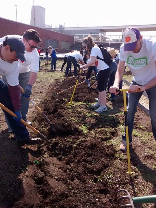 Rotary club members tilling the planting soil